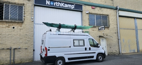 Furgoenta camper con kayak canoa en el techo